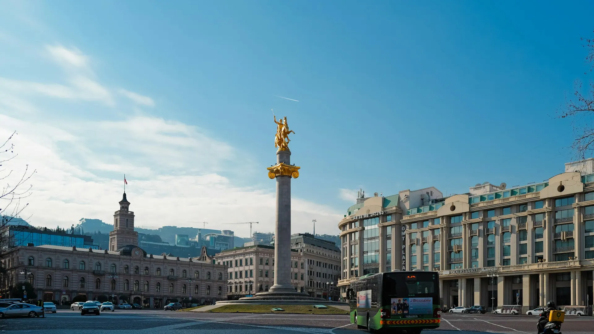 Frihetstorget i Tbilisi med stadshusets klocktorn och georgiska flaggan Frihetstorget i Tbilisi med stadshusets klocktorn och georgiska flaggan